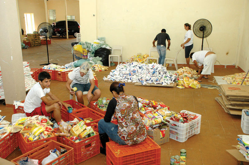 Voluntários separam alimentos no galpão do Natal Sem Fome em Sorocaba, perto do terminal São Paulo