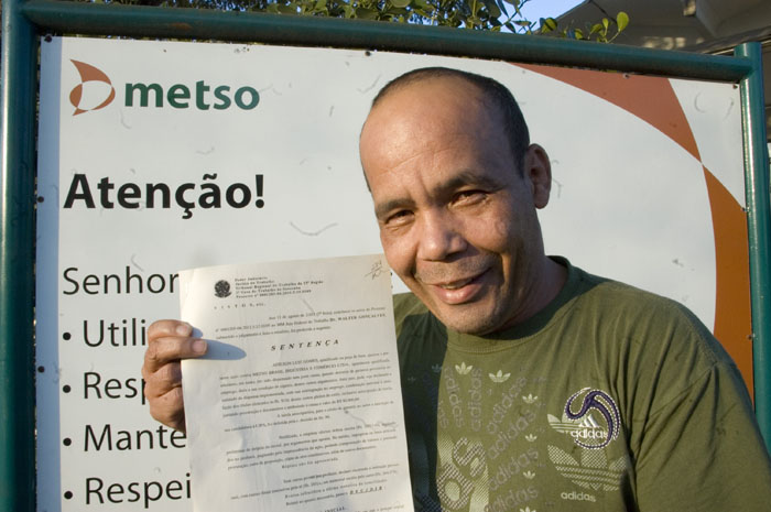 Adilson com cópia da sentença judicial em frente à Metso Equipamentos, onde ele volta a trabalhar e atuar como cipeiro