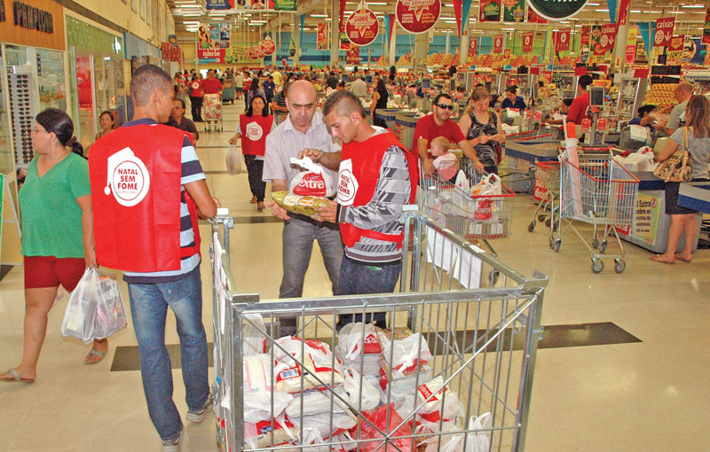 Voluntários dentro de supermercado Extra/Santa Rosália abordam cliente, que se sensibiliza e faz doação