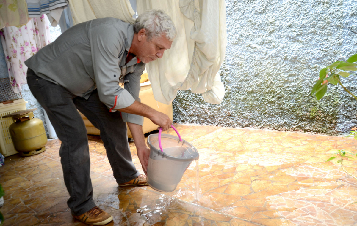 Em sua residência, Joselito Mansinho, utiliza água da máquina para lavar o quintal