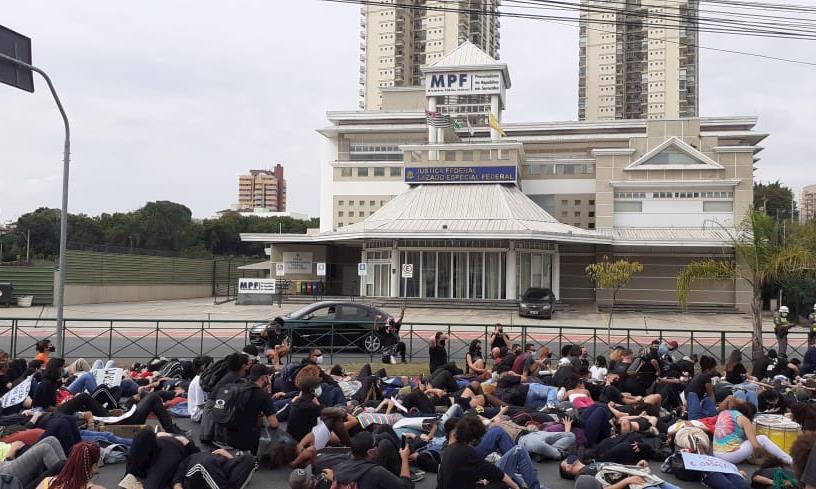 Manifestantes sentaram na rua, ergueram os punhos e entoaram a frase “eu não consigo respirar”