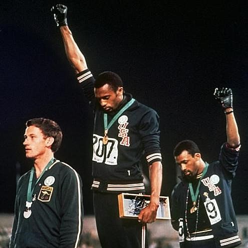 John Carlos e Tommie Smith - ouro e bronze nos 200 metros rasos do atletismo, protestam de punhos cerrados em alusão ao movimento Black Power
